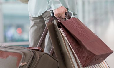 Mature woman waiting at airport with shopping bags