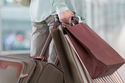 Mature woman waiting at airport with shopping bags